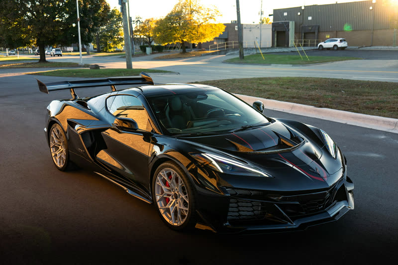 Black Corvette Z06 with a rear wing in warm evening light