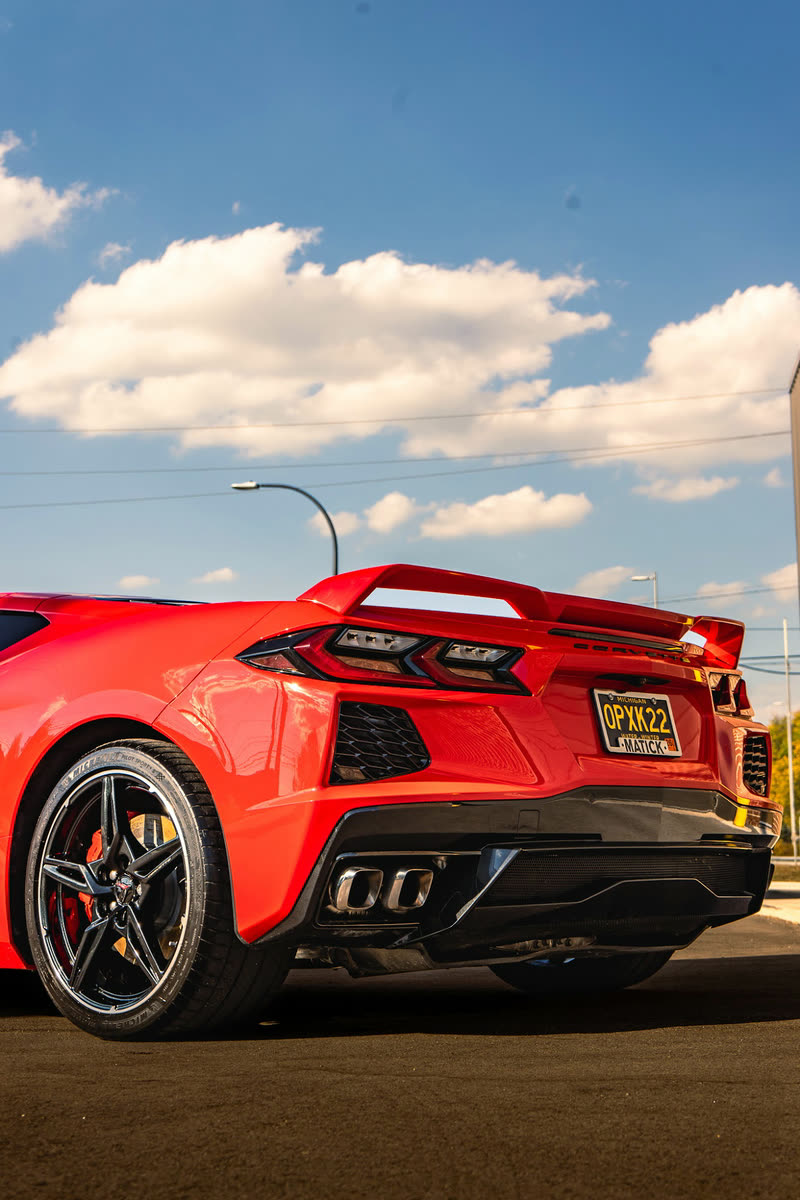 Red Corvette from the rear under a blue sky
