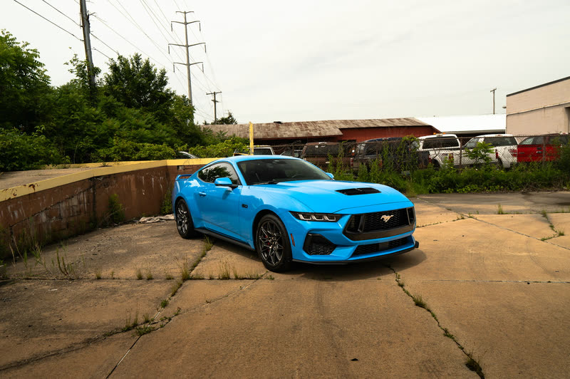 Blue Ford Mustang on a paved lot