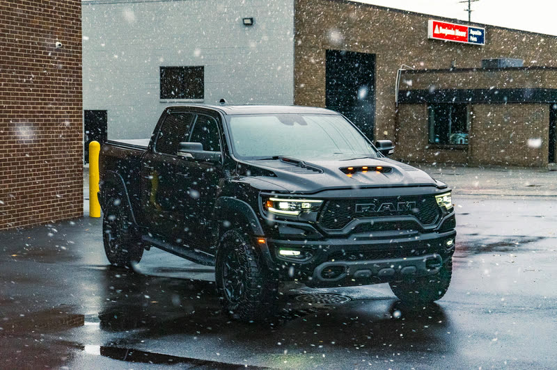 Black Ram TRX pickup in light snow in front of a brick building