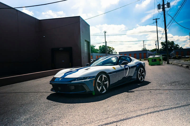 Grey Ferrari 12Cilindri with a blue and white stripe, front three-quarter view