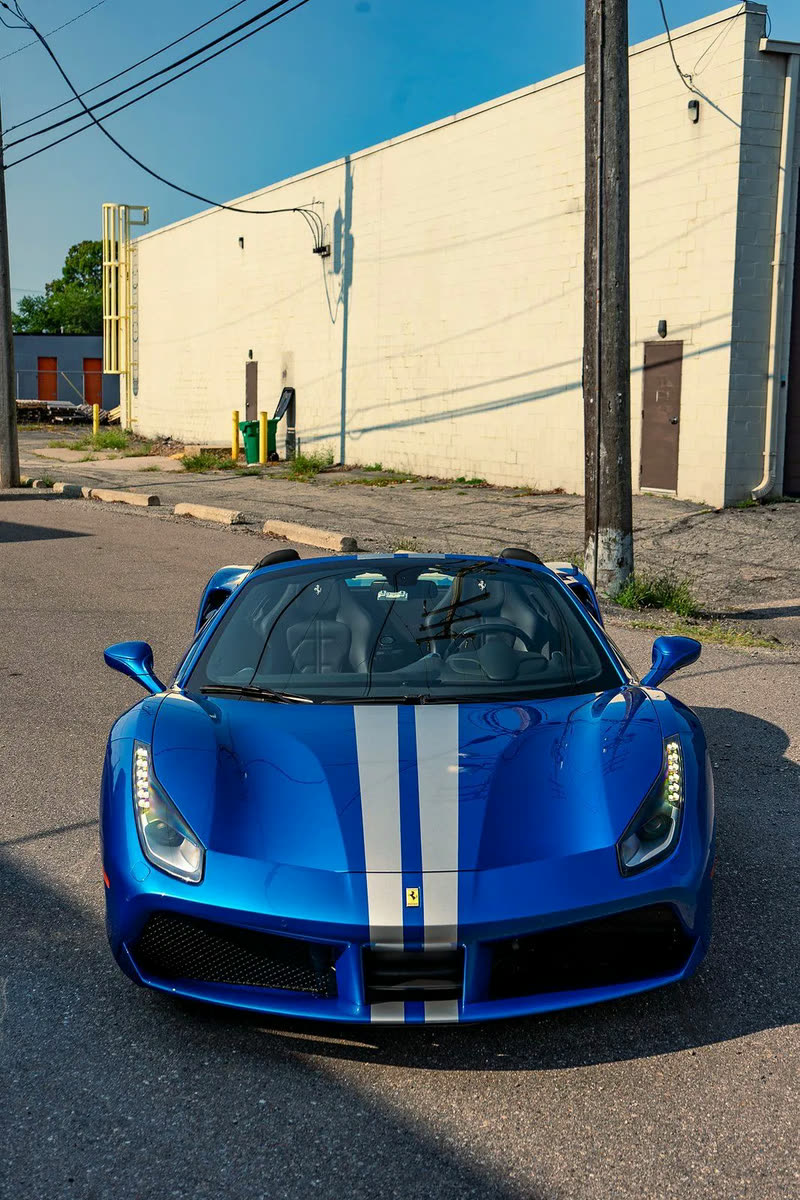 Blue Ferrari 488 Spider with white stripes, front view