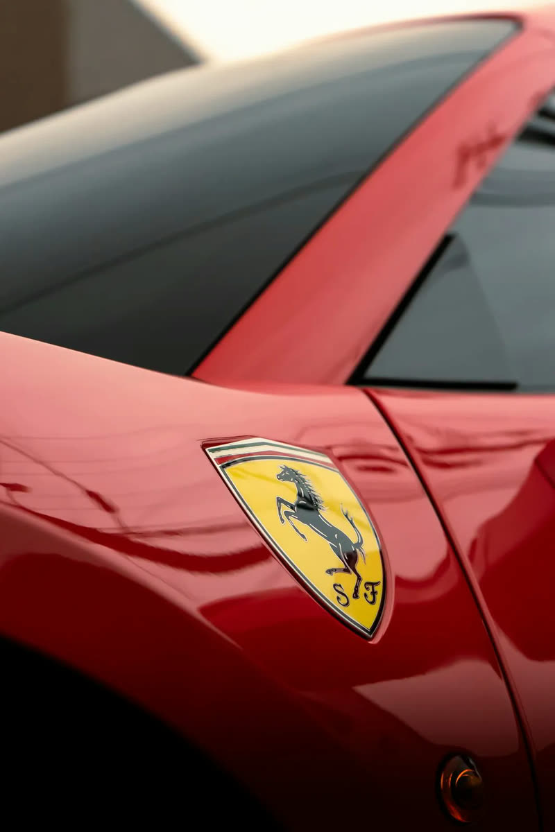 Close-up of the Ferrari shield badge on a red fender